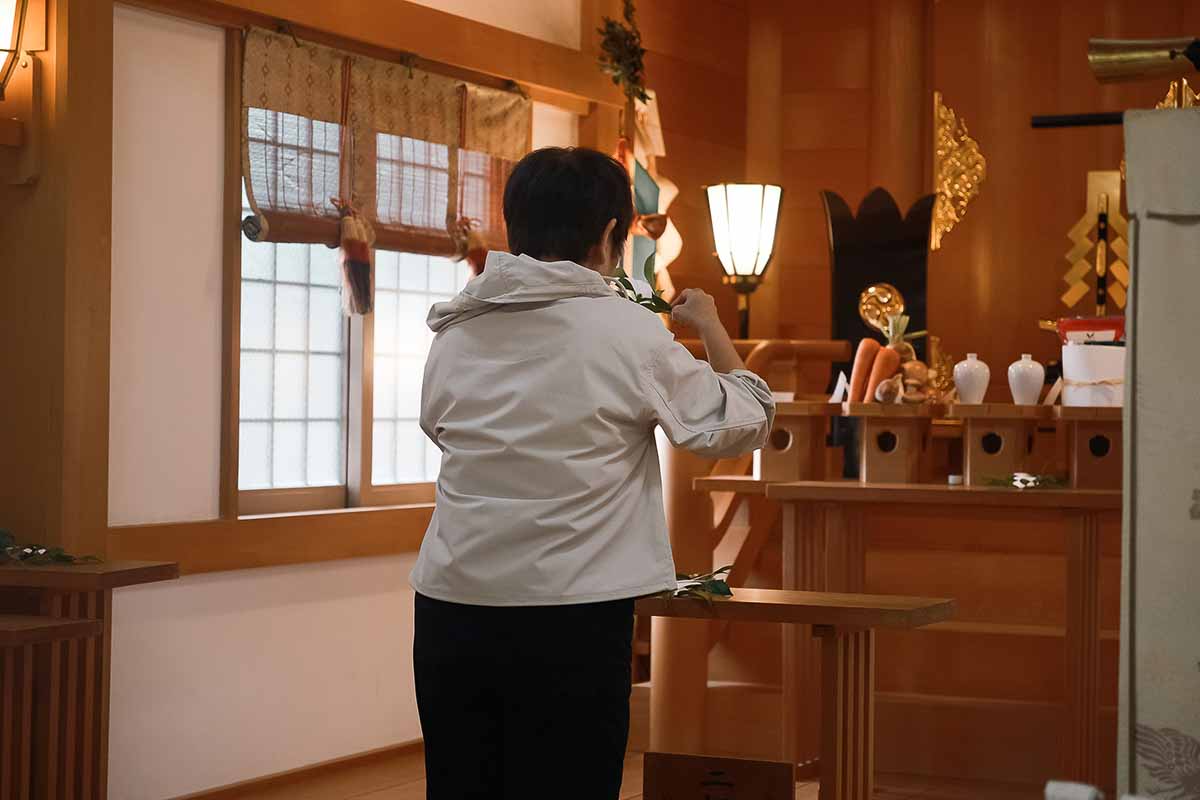神社でお参りする人